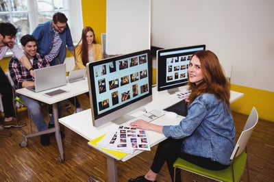 Attractive photo editor working on computers in the office