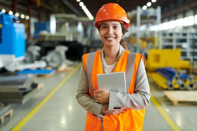 Smiling engineer with a tablet and a hardhat