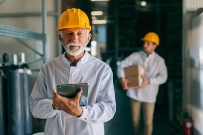 Older engineer with a hard hat and tablet