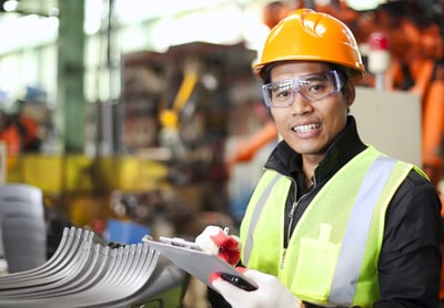 Smiling Asian American factory worker with a clipboard