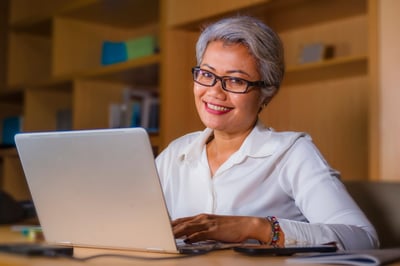 Smiling older businesswoman at a computer