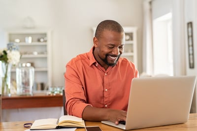 Smiling Black businessman at a computer
