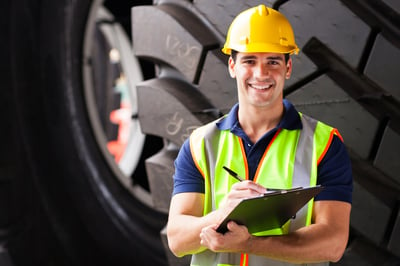 Smiling industrial worker wearing a hard hat and high vis vest