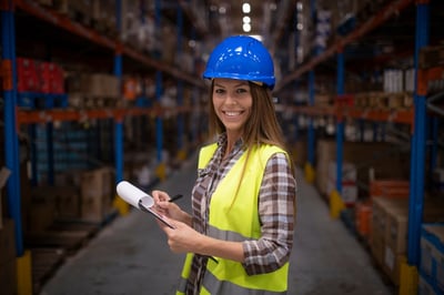 Smiling female industrial worker with a clipboard