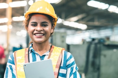 Smiling female industrial worker with a tablet