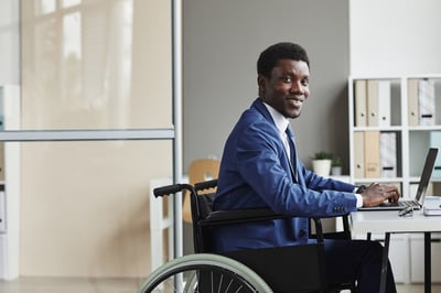 Smiling Black businessman at a computer