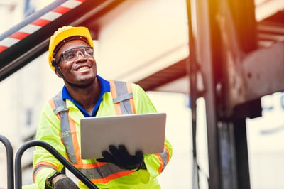 Smiling African-American engineer holding a laptop