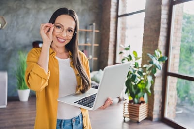 Smiling businesswoman with a laptop and yellow jacket