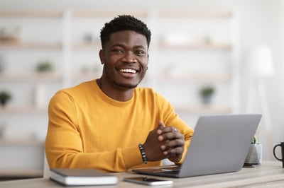 Smiling Black Businessman at a Computer