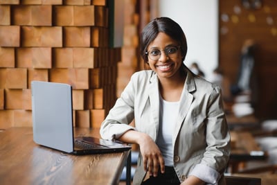 Smiling female procurer of color with a laptop