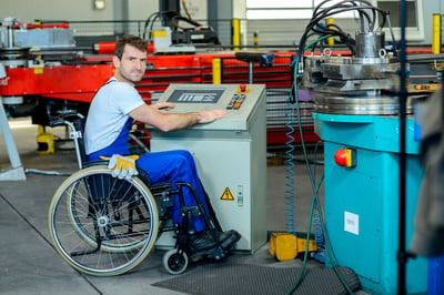 Industrial worker in a wheelchair operating equipment