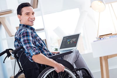 Smiling engineer in a wheelchair with a laptop